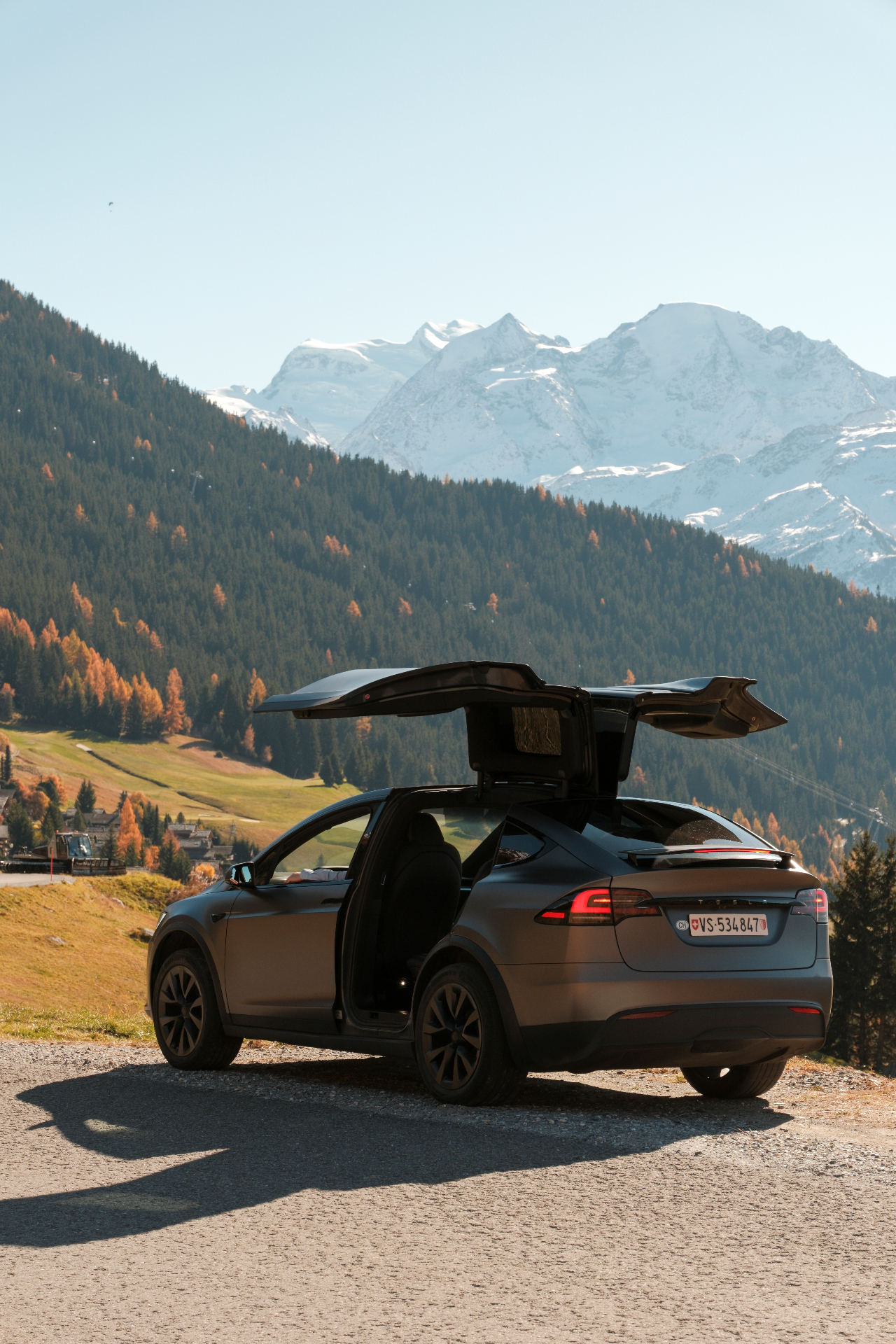 Tesla Model X with falcon-wing doors open above Verbier